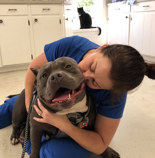 A Kilgore staff member hugging a happy dog
